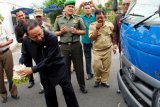 Paringin, 26/3 - TRUK SAMPAH BANTUAN ADARO - Bupati Balangan, Sefek Effendie melakukan prosesi "Tapung Tawar" menandai dioperasikannya satu unit Arm Roll Truck pengangkut sampah yang berasal dari bantuan perusahaan pertambangan nasional, PT Adaro Indonesia melalu program Corporate Social Responsibility (CSR). Dengan adanya bantuan tersebut, jumlah truk armada pengangkut sampah di Balangan menjadi enam buah yang diharapkan dapat lebih meningkatkan pelayanan kebersihan kepada masyarakat. Foto: ANTARA/Rusmanadi