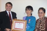 Tokoh demokrasi Myanmar Aung San Suu Kyi (tengah) mendapat penghargaan The Sukarno Prize. Penghargaan itu diberikan Presiden The Sukarno Center, Dr Shri I Gusti Ngurah Arya Wedakarna, dan Ketua Dewan Pembina The Sukarno Center, Sukmawati Sukarno Putri, di kediaman Suu Kyi di Yangon, Myanmar, 29 Maret 2012. Foto: Istimewa  