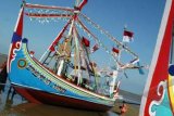 Pamekasan (Antara Bali) - Sejumlah warga berada di dekat perahu hias di Pantai Jumiang, Pamekasan, Jatim, Kamis (19/4). Nelayan di daerah itu mempercantik perahu mereka guna memeriahkan perayaan Petik Laut yang digelar tanggal 19 hingga 21 April 2012. FOTO ANTARA/Saiful Bahri/2012.