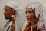 Sepasang calon pengantin mengucapkan ijab kabul pada nikah massal se Kecamatan Medan Petisah, Sumut, Sabtu (7/4). Nikah massal yang diikuti 18 pasangan pengantin tersebut, untuk membantu masyarakat mendapatkan legalitas pernikahan sesuai dengan ketentuan yang berlaku. FOTO ANTARA/Irsan Mulyadi/12