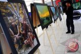 Seorang pengunjung mengamati foto yang ditampilkan dalam Pameran Foto 'Ragam Budaya Dalam Lensa' di Museum Negeri, Pontianak, Kalbar, Kamis (12/4). Pameran foto yang diadakan oleh Pontianak Photographer Community (PPC) tersebut, menampilkan puluhan karya yang bercerita tentang ragam budaya Kalbar. FOTO ANTARA/Jessica Helena Wuysang 