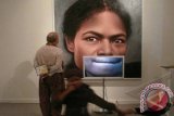 Seorang pengunjung mengamati sebuah kreasi berjudul "Face Biografi - Perempuan Papua", karya Galam Zulkifli, pada acara pembukaan "Pameran Arsip Seni Rupa Indonesia", di Galeri Nasional, Jakarta, Minggu (8/4) malam. Pameran yang menampilkan sebanyak 63 perupa ini akan berlangsung hingga 20 April 2012. FOTO ANTARA/Dodo Karundeng/12