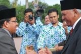 Samarinda (ANTARA News Kaltim) - Gubernur Kaltim, Awang Faroek Ishak saat menyerahkan penghargaan dan beasiswa pada peringatan Hari Pendidikan Nasional (Hardiknas) yang digelar di Halaman Kantor Gubernur Kaltim, Samarinda, Rabu (2/5). Gubernur Kaltim Awang Faroek Ishak menyerahkan beasiswa senilai Rp137 miliar bagi lebih dari 30.000 pelajar dan mahasiswa. (M. Ghofar/ANTARA) 
