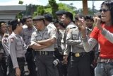 Samarinda (ANTARA News Kaltim) -  Seorang buruh berjoget di hadapan puluhan polisi pada aksi unjuk rasa memperingati hari Buruh Sedunia yang berlangsung di depan Kantor Gubernur Kaltim di Samarinda, Selasa (1/5). Unjuk rasa yang dilakukan ratusan buruh dari berbagai perusahaan di Samarinda itu menuntut dinaikkannya Upah Minimum Provinsi (UMK) pada 2013 sesuai KHL (Kebutuhan Hidup Layak) yakni minimal Rp1,6 juta per bulan. 9AMIRULLAH/ANTARA)