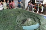 Kintamani (Antara Bali) - Sejumlah pelajar melihat maket Gunung api Batur di Museum Gunungapi Batur, Kintamani, Bangli, Bali, Minggu (3/6). Di museum seluas 1,09 hektar itu pengunjung akan disuguhkan informasi sejarah letusan Gunung api Batur dan sejumlah informasi tentang gunung berapi lainnya di Indonesia termasuk juga berbagai koleksi jenis batuan. FOTO ANTARA/Widodo S. Jusuf/2012.