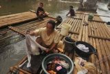 Jakarta (antara Bali) - Seorang ibu mencuci di atas rakit di sungai Ciliwung, Kampung Pulo, Jatinegara, Jakarta Timur, Rabu (6/6). Berdasarkan data Kementerian Lingkungan Hidup (KLH), 80 persen pencemaran di Sungai Ciliwung disebabkan karena limbah domestik dan hampir semua warga yang bermukim di wilayah tersebut memanfaaatkan air sungai tersebut untuk keperluan sehari-hari. FOTO ANTARA/Zabur Karuru/2012.