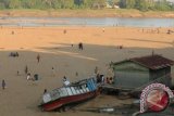 Sejumlah warga berada di di tepian Sungai Kapuas yang mengering ketika permukaan sungai tersebut surut di Kabupaten Sintang, Selasa (26/6). Rendahnya curah hujan selama sebulan terakhir di Kabupaten Sintang, menyebabkan Sungai Kapuas megalami penyurutan dan mengakibatkan transportasi air menjadi terhambat. FOTO ANTARA/Sugeng Hendratno