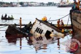 Sejumlah warga berada di sekitar kapal tongkang (ponton) bermuatan minyak kelapa sawit atau Crude Palm Oil (CPO) yang bocor dan karam di Sungai Kapuas, Pontianak, Kalbar, Kamis (7/6). FOTO ANTARA/Jessica Helena Wuysang