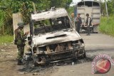 Aparat TNI dan Polri memeriksa kendaran milik Polisi yang dibakar massa di Kwamki Lama, Timika, Papua, Senin (18/6). Tiga kendaraan milik Polisi dibakar dan satu kendaraan dirusak salah satu kelompok warga yang kesal karena melerai mereka untuk saling serang. Selain itu 4 Personil Kepolisian juga terluka kena panah.  (FOTO ANTARA/Spedy Paereng).  
 
