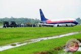 Sejumlah anggota TNI AU Lanud Supadio dan petugas Bandara Supadio berada di sekitar pesawat Sriwijaya Air jurusan Jakarta-Pontianak yang tergelincir di landasan Bandara Supadio, Kabupaten Kubu Raya, Kalbar, Jumat (1/6). Akibat hujan lebat yang disertai angin kencang, pesawat Sriwijaya Air SJ 188 jenis 737-400 Reg PKCJV rute Jakarta-Pontianak berpenumpang 163 orang, tergelincir saat mendarat hingga mengakibatkan pesawat keluar dari landasan, tidak terdapat korban jiwa dalam peristiwa tersebut. FOTO ANTARA/Jessica Helena Wuysang/ss/pd/12