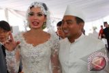 Model dan artis Catherine Wilson (kanan) bersama suaminya Achmad Mucholas Arofat seusai melakukan akad nikah yang dilangsungkan di Masjid Raya Pondok Indah, Jakarta Selatan, Jumat (1/6). Akad nikah berkonsep nuansa putih itu, ,Achmad Mucholas Arofat memberikan mas kawin uang Rp.1 juta dan seperangkat alat shalat. FOTO ANTARA/pool/Yayat Ruhayat