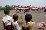 Tiga orang anak melihat 7 pesawat latih tempur jenis KT 1B Wong Bee, yang dibawa Jupiter Aerobatic Team TNI AU, di Lanud Medan, Sumut, Senin (25/6). Kedatangan 7 pesawat latih tempur tersebut, untuk mengenalkan kepada masyarakat tentang kemampuan pesawat yang akan mengikuti kegiatan 100 tahun Aviasi Thailand. (FOTO ANTARA/Irsan Mulyadi)