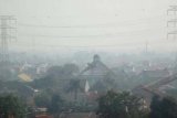 Tangerang (Antara Bali) - Kawasan pemukiman terlihat diselimuti asap di Cipondoh, Kota Tangerang, Jumat (13/7). Pemkot Tangerang berupaya mengatasi pencemaran udara dengan membangun kampung sehat hijau, 'Car Freeday', dan meninjau kembali sejumlah pabrik maupun industri yang beroperasi di sekitar pemukiman dan sekolah. FOTO ANTARA/Iggoy el Fitra/2012.