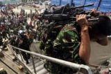 Makassar (Antara Bali) - Seorang prajurit TNI AD dari Batalyon Infanteri (Yonif) 721 Makasau yang akan bertugas menjaga perbatasan RI-Papua Nugini, memanggul sejumlah senjata laras panjang ketika menaiki KRI Banjarmasin di Pelabuhan Soekarno-Hatta Makassar, Sulsel, Senin (16/7). Sebanyak 650 prajurit tersebut akan bertugas selama enam bulan di perbatasn itu. FOTO ANTARA/Yusran Uccang/2012.