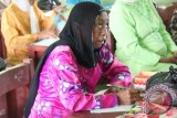 Barabai, 17/7 - PEMBERANTASAN BUTA AKSARA - Seorang ibu peserta pemberantasan buta aksara serius memperhatikan keterangan dari guru pengajar di ruang SDN Kambat Kecamatan Pendawan Hulu Sungai Tengah, Senin (16/7). Pemberantasan buta aksara tersebut dilaksanakan oleh Kodim 1002 Barabai.(Foto ANTARA/Fathur/humas/C)