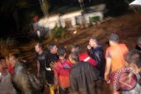 Tim SAR bersama warga berusaha menolong warga di sebuah rumah yang terkepung banjir bandang di Kelurahan Limaumanis, Kec. Pauh, Padang, Sumbar, Selasa (24/7) malam. Banjir bandang tersebut menyebabkan puluhan rumah di bantaran Sungai Limaumanis dan Batangkuranji dihantam arus air yang membawa material kayu dan batu. FOTO ANTARA/Iggoy el Fitra/Koz/Spt/12.