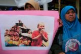 Mahasiswa dari Kesatuan Aksi Mahasiswa Muslim Indonesia (KAMMI) Aceh memerlihatkan foto para pengungsi Rohingya kepada pengguna jalan saat aksi solidaritas di Simpang Lima, Banda Aceh, Minggu (29/7). Aksi solidaritas mahasiswa itu menyerukan kepada pemerintah Myanmar memberikan kewarganegaraan terhadap suku Rohingya dan Negara Asean serta PBB segera bertindak menyelamatkan warga Rohingya , karena sudah terjadi pelanggaran HAM berat oleh Pengusa Militer Myanmar terhadap suku Rohingnya.FOTO ANTARA/Ampelsa