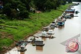 Beberapa rumah lanting dan kapal berada di tepian Sungai Kapuas, di Kabupaten Sintang, Kalbar, Kamis (19/7). Kehidupan masyarakat di tepian Sungai Kapuas di Kabupaten Sintang tersebut, menjadi salah satu objek unik yang kerap diabadaikan dengan menggunakan kamera foto atau video oleh para wisatawan lokal dan mancanegara. FOTO ANTARA/Jessica Helena Wuysang/ed/mes/12