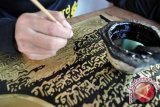 Pekerja menyelesaikan pembuatan relief kaligrafi di atas lempengan Kuningan di galeri seni "Karya Abadi" Desa Rejosari, Pringsurat, Pringsurat, Temanggung, Jateng, Selasa (7/8). (FOTO ANTARA/Anis Efizudin).
