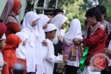 Gitaris band Wali, Apoy (kanan) saat memberikan sedekah kepada anak yatim dalam acara "Roadshow Wali, Cari Berkah Ayo Sedekah" di Masjid Raya Pondok Indah, Jakarta, Rabu, (1/8). FOTO ANTARA/Agus Apriyanto/pd/12