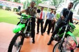 Wakapolda Kalbar, Kombes (Pol) Safaruddin (kiri) bersama Agen Federal dari Australian Federal Police (AFP), Angus Mc Gilvray (kanan) duduk di atas motor, saat penyerahan hibah di Mapolda Kalbar, Selasa (25/9). Australian Federal Police (AFP) memberikan hibah berupa dua unit sepeda motor dan seperangkat alat operasional penyelidikan kepada Direktorat Reserse Kriminal Umum (Dit Reskrimum) Polda Kalbar, karena dinilai selama ini telah berhasil mengungkap sejumlah kasus imigran gelap yang diselundupkan melalui pintu perbatasan Indonesia-Malaysia di wilayah Kalbar. FOTO ANTARA/Jessica Helena Wuysang/ss/ama/12