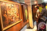 Sejumlah pengunjung mengamati lukisan saat pameran budaya di Aula SMAK St. Albertus, Malang, Jawa Timur, Sabtu (15/9). Pameran yang berlangsung selama 7 hari tersebut menampilkan sekitar 30 lukisan dari 16 perupa yang sebagian besar menggambarkan kisah-kisah di Alkitab. FOTO ANTARA/Ari Bowo Sucipto