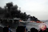 Sejumlah warga menyaksikan kapal siluman, KRI Klewang 625 yang terbakar di dermaga Pangkalan TNI AL Banyuwangi, Jawa Timur, Jumat (28/9). Kebakaran KRI Klewang masih diselidiki penyebabnya. FOTO ANTARA/HO/Seno S./ed/mes/12.