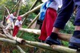 Padang (Antara Bali) - Pelajar SD bersama orangtuanya meniti jembatan bambu saat menyeberangi Sungai Batang Sungkai untuk ke sekolah di Kelurahan Lambung Bukit, Padang, Sumbar, Selasa (23/10). Jembatan bambu itu dibangun secara sederhana hasil gotong-royong masyarakat karena putusnya akses jembatan permanen dari Kelurahan Kapalo Koto ke Lambung Bukit pasca banjir bandang beberapa waktu lalu. FOTO ANTARA/Iggoy el Fitra/nym/2012.