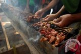 Sejumlah santri mengikuti bakar sate massal di halaman Ponpes Tebuireng, Jombang, Jawa Timur, Jumat (26/10). Tradisi bakar sate masal itu bertujuan untuk mempererat ikatan emosional sesama santri dan pengurus Ponpes. FOTO ANTARA/SYAIFUL ARIF/12