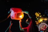 Seorang warga penganut Buddha menerbangkan lampion pada perayaan Festival Kue Bulan atau Cung Chiu Giek di Maha Vihara Maitreya, Kab Kubu Raya, Kalbar, Minggu (30/9) malam. Pelepasan lampion ke udara tersebut, diiringi dengan doa memohon berkat dan keselamatan kepada Dewi Bulan. FOTO ANTARA/Jessica Helena Wuysang