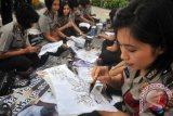 Sejumlah polisi wanita (Polwan) jajaran Polrestabes Surabaya, membuat batik tulis di Taman Bungkul, Surabaya, Jatim, Senin (1/10). Kegiatan melestarikan budaya bangsa Indonesia tersebut untuk memperingati Hari Batik Nasional pada Selasa (2/10). FOTO ANTARA/M Risyal Hidayat