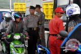 Amuntai (7/11) - PANTAU SPBU - Tim pemantau gabungan dari Polres, Kodim 1001 Amuntai dan anggota Satpol PP memperhatikan aktivitas di salah satu SPBU di Amuntai, Rabu (7/11). Kegiatan penertiban pembelian solar dan premium di SPBU ini sebagai tindak lanjut dari Surat Gubernur Kalsel, banyaknya pelansir yang menguasai SPBU mengakibatkan kemacetan ruas badan jalan khususnya di Muara Tapus dan Desa Panangkalaan. (Foto Humas-Eddy/D)
 