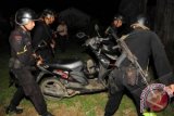 Sejumlah pasukan Geganan Polda Sulselbar mengamankan motor milik terduga teroris saat melakukan penyergapan terhadap dua terduga teroris di Kompleks Bukit Hijau Permai, Moncongloe, Maros, Sulsel, Minggu (11/11) malam. Penyergapan tersebut terkait pengembangan dari teror bom kepada Gubernur Sulsel Syahrul Yasin Limpo yang juga ketua DPD Golkar Sulsel saat menrayakan HUT Partai Golkar. FOTO ANTARA/Sahrul Manda Tikupadang/YU/ed/pd/12