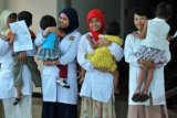 Jember (Antara Bali) - Beberapa perawat menggendong anak dengan HIV-AIDS di Rumah Sakit Daerah (RSD) dr. Soebandi, Jember, Jawa Timur, Sabtu (1/12). RSD dr Soebandi Jember mencatat ada 190 orang dengan HIV-AIDS (ODHA) di tahun 2012 ini yang berobat di RSD tersebut, sembilan orang diantaranya meninggal dunia. FOTO ANTARA/Seno S./nym/2012.