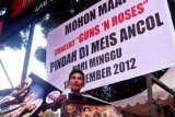 Jakarta (Antara Bali) - Seorang pedagang poster menjajakan dagangannya di depan pintu masuk tempat konser Guns N Roses di Lapangan Senayan, Jakarta Sabtu (15/12). Konser Group musik rock legendaris asal Amerika tersebut diundur hingga besok Minggu (16/12) pukul 13.00 wib di Mata Elang International Stadium (MEIS) Ancol Jakarta. FOTO ANTARA/Pey Hardi Subiantoro/nym/2012.