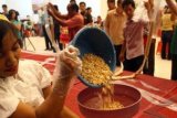 Surabaya (Antara Bali) - Pengusaha tempe dibantu sejumlah pengunjung membuat tempe sepanjang 100 meter dalam festival makanan vegetarian di Surabaya, Jatim, Sabtu (22/12). Pembuatan tempe 100 meter tersebut membutuhkan kedelai sebanyak 80 kilogram. FOTO ANTARA/M Risyal Hidayat/nym/2012.