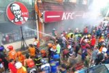 Banjarmasin (Antara Bali) - Petugas pemadam kebakaran berusaha memadamkan api yang menghanguskan sebagian restoran cepat saji KFC Banjarmasin, Kamis (27/12). Kebakaran yang diduga disebabkan karena kebocoran tabung gas elpiji 50 kilogram itu mengakibatkan satu karyawan bagian dapur terluka, sementara kerugian belum dapat diperkirakan. Foto ANTARA/Herry Murdy Hermawan/nym/2012.