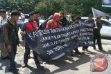 Belasan mahasiswa yang tergabung dalam Solidaritas Mahasiswa Pengemban Amanat Rakyat (Solmadapar) Kalimantan Barat, Kamis, berunjuk rasa mendesak Kepolisian Daerah setempat untuk menuntaskan kasus-kasus korupsi di provinsi itu. "Polda Kalbar sepertinya tertidur pulas, karena hingga kini tidak pernah menyelesaikan satu kasuspun untuk kasus korupsi," kata Sekretaris Jenderal Solmadapar Kalbar Yunus saat menyampaikan orasinya di depan pintu masuk Mapolda Kalbar, di Pontianak.
