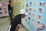 Nunukan (ANTARA Kaltim) - Seorang pengunjung pameran sedang mengamati foto sejarah Kabupaten Nunukan pada pameran foto sejarah yang digelar Kantor Perpustakaan, Arsip dan Dokumentasi Kabupaten Nunukan Minggu (9/12). (M Rusman/ANTARA)
