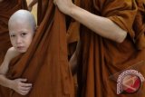 Hendri (9) berganti jubah dalam prosesi pelantikan menjadi samanera (calon biksu) dalam program "Pabbajja Samanera" (pelatihan calon biksu) di Vihara Jakarta Dhammacakka Jaya, Sunter, Jakarta Utara, Sabtu (22/12). Hendri memanfaatkan libur dua minggunya untuk menggeluti ajaran Buddha dan mengecap kehidupan sebagai biksu dalam program tersebut. FOTO ANTARA/Fanny Octavianus