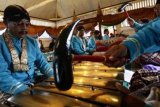 Yogyakarta (Antara Bali) - Sejumlah abdi dalem menabuh gamelan Kiai Guntur Madu di Pagongan Masjid Gede Kauman, Yogyakarta, Jumat (18/1). Gamelan Kyai Guntur Madu dan Kyai Nogo Wilogo yang dibuat pada jaman pemerintahan Sultan Agung Hanyokrokusuma 1630 Masehi itu akan ditabuh selama tujuh hari berturut-turut untuk menandai dimulainya perayaan sekaten yang digelar sebelum peringatan hari kelahiran Nabi Muhammad SAW. FOTO ANTARA/Noveradika/nym/2013.