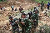 Agam (Antara Bali) - Sejumlah anggota TNI mengangkat jenazah korban longsor, di Daerah Kapuang Dadok, Nagari Sungai Batang, Kabupaten Agam, Sumbar, Minggu (27/1). Sedikitnya enam orang meninggal dunia, 17 orang masih dinyatakan hilang dan 12 unit rumah tertimbun longsoran. FOTO ANTARA/Arif Pribadi/nym/2013. 