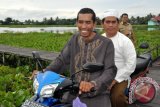 Amuntai,(23/1) - HARUS NAIK MOTOR - Bupati Hulu Sungai Utara Drs H Abdul Wahid HK harus naik motor saat melakukan kunjungan ke desa-desa terpencil di wilayahnya seperti saat mengunjungi Desa Kayakah Kecamatan Amuntai Selatan, Rabu (23/1) karena sebagian besar wilayah kabupaten yang berstatus kabupaten tertinggal di Propinsi Kalimantan Selatan ini sebagian besar adalah lahan lebak atau rawa sehingga banyak mengandalkan sarana transportasi berupa jalan urukan, titian, jembatan hingga transportasi air.(Foto ANTARA/Eddy-Humas/AK)