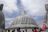 Wisatawan mengamati sejumlah stupa yang ditutup mantel di objek wisata Candi Borobudur, Magelang, Jawa Tengah, Sabtu (12/1). Sebanyak 43 stupa teras dan 1 stupa induk ditutup mantel terpaulin sebagai antisipasi dampak material vulkanik dalam simulasi mitigasi bencana erupsi Gunung Merapi yang berlangsung dari 10 hingga 14 Januari 2013. FOTO ANTARA/Sigid Kurniawan