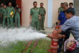 Tenggarong (ANTARA Kaltim) - Kepala Badan Penanggulangan Bencana Daerah (BPBD) Kabupaten Kutai Kartanegara Darmansyah (berkacamata) bersama tim mencoba hydrant di luar perkantoran, untuk mengecek kesiapan alat pemadam kebakaran. (Hayru Abdi/ANTARA Kaltim)