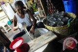 Pembuat Kue Keranjang, Tan Ngen Cuan (83) menuangkan adonan Kue Keranjang yang terbuat dari beras ketan dan gula pasir ke dalam wadah cetakan, di kediamannya di Jalan Veteran Pontianak, Kalbar, Sabtu (26/1). Kue Keranjang khas Imlek seharga Rp24 ribu per kilogram yang diproduksi oleh usaha rumahan Tan Ngen Cuang sejak 40 tahun lalu tersebut, didistribusikan di Kota Pontianak dan wilayah hulu Kalimantan Barat. FOTO ANTARA/Jessica Helena Wuysang

