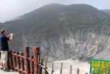 Bandung (Antara Bali) - Wisatawan mancanegara mengabadikan panorama di kawah gunung api Tangkuban Perahu, Bandung, Provinsi Jawa Barat, Sabtu (2/2). Gunung Tangkuban Perahu yang dikaitkan dengan legenda Sangkuriang mempunyai ketinggian 2.084 meter di atas permukaan laut, merupakan gunung api aktif yang statusnya diawasi oleh Direktorat Vulkanologi. FOTO ANTARA/Irwansyah Putra/nym/2013.