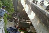 Tabanan (Antara Bali) - Sejumlah pengendara melihat truk yang jatuh ke jurang di Pesiapan, Tabanan, Bali, Selasa (5/2). Truk bernomor plat DK9472WF yang mengangkut berbagai makanan ringan itu menabrak pembatas jembatan pada Senin (4/2) sekitar pukul 23.30 Wita dari arah Jembrana. FOTO ANTARA/Nyoman Budhiana/nym/2013.