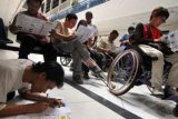 Jakarta (Antara Bali) - Penyandang disabilitas mengikuti tes tertulis saat pembuatan Surat Izin Mengemudi (SIM) D khusus difabel di Satuan Penyelenggara Administrasi (Satpas) SIM Daan Mogot, Jakarta, Senin (11/2). Kegiatan yang diikuti oleh sekitar 40 penyandang disabilitas dimaksudkan untuk tertib berlalulintas. FOTO ANTARA/Zabur Karuru/nym/2013.