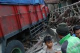 Pati (Antara Bali) - Warga menyaksikan truk bermuatan kaleng sarden yang menabrak rumah warga di jalur pantura yang Pati-Rembang, Batangan, Pati, Jateng, Sabtu (16/2). Kecelakaan tunggal itu terjadi akibat truk berusaha menghindari kendaraan lain. FOTO ANTARA/Andreas Fitri Atmoko/nym/2013.